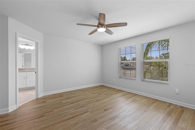 unfurnished room with light wood-type flooring, ceiling fan, and a textured ceiling