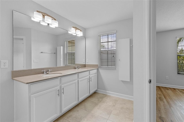 bathroom featuring a textured ceiling, a healthy amount of sunlight, vanity, and hardwood / wood-style floors