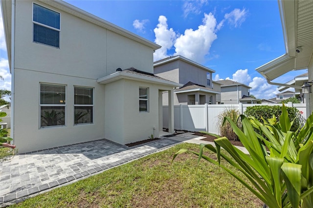 rear view of property with a lawn and a patio