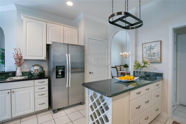 kitchen with stainless steel refrigerator with ice dispenser, crown molding, light tile patterned flooring, a notable chandelier, and pendant lighting