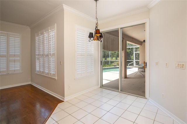 entryway featuring crown molding, light tile patterned flooring, and a notable chandelier