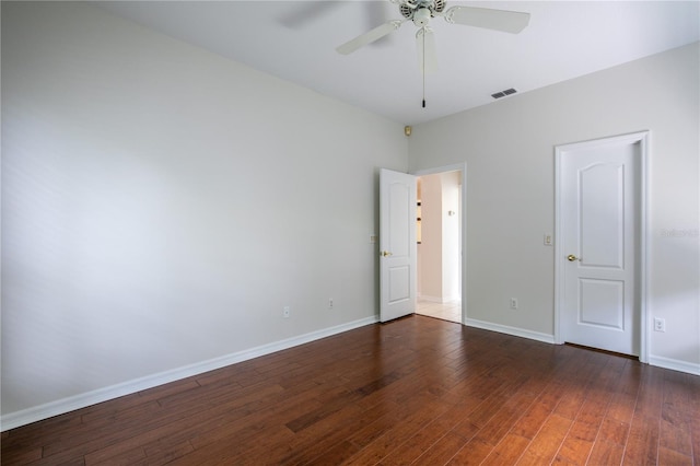 spare room featuring dark wood-type flooring and ceiling fan