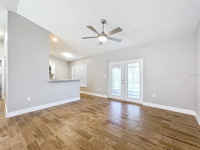 unfurnished living room featuring wood-type flooring, lofted ceiling, french doors, and ceiling fan