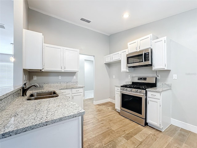 kitchen with white cabinets, stainless steel appliances, light wood-type flooring, and sink