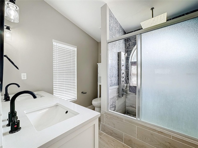 bathroom featuring lofted ceiling, vanity, toilet, and a shower with shower door