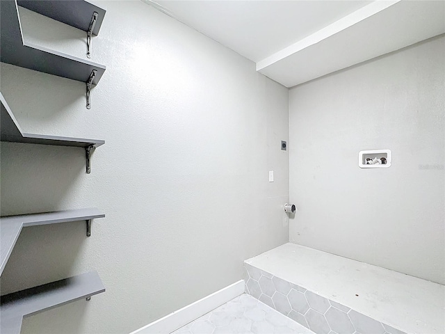 clothes washing area featuring light tile patterned flooring and washer hookup