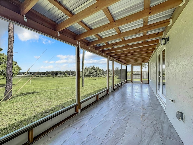 unfurnished sunroom featuring beamed ceiling