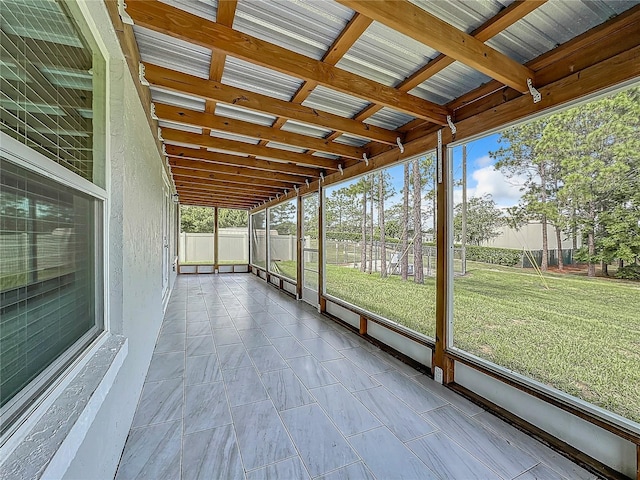 unfurnished sunroom with beamed ceiling