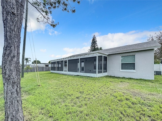 back of house featuring a sunroom and a yard