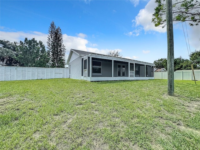 back of property featuring a yard and a sunroom