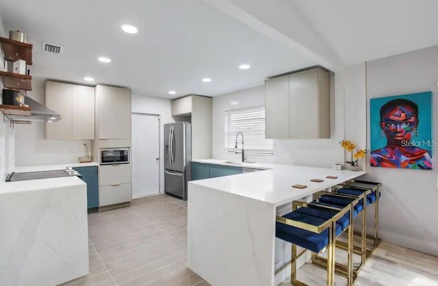 kitchen with kitchen peninsula, sink, stainless steel appliances, and a breakfast bar