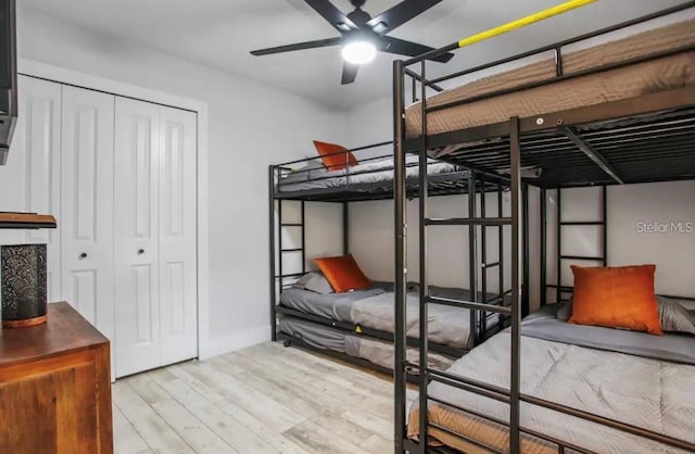 bedroom with ceiling fan, a closet, and light hardwood / wood-style floors