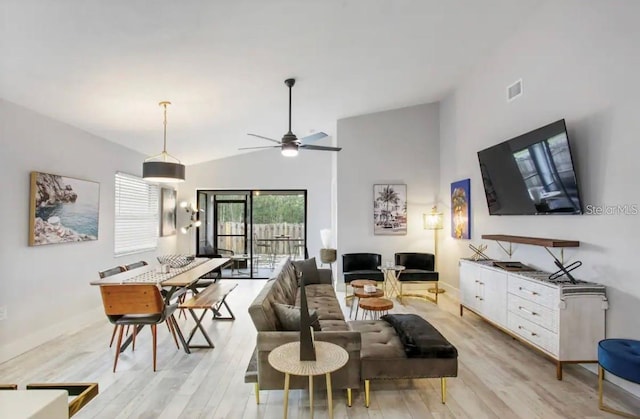 living room featuring ceiling fan, light wood-type flooring, and vaulted ceiling