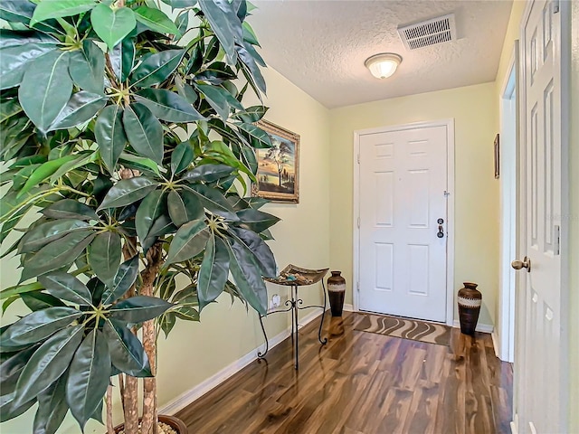 entrance foyer featuring a textured ceiling and dark hardwood / wood-style flooring