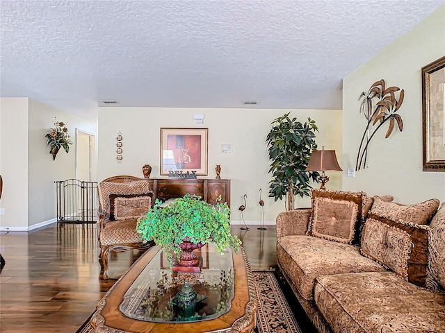 living room featuring a textured ceiling and dark hardwood / wood-style flooring