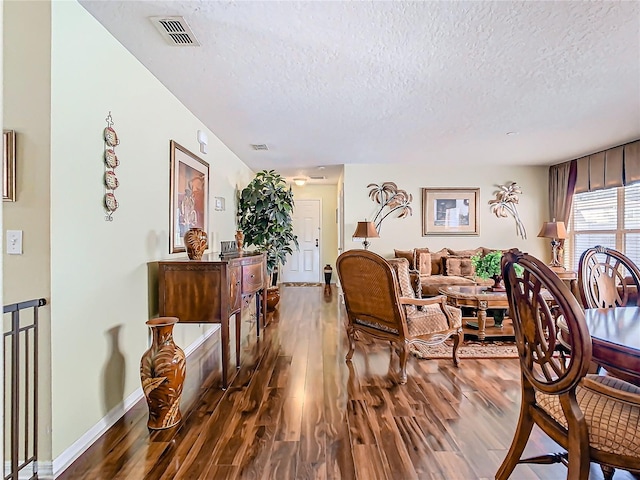 living room with a textured ceiling and dark hardwood / wood-style floors