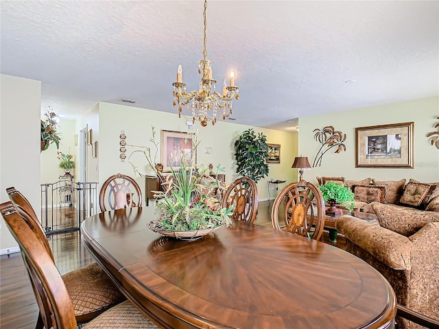 dining room featuring hardwood / wood-style flooring, a chandelier, and a textured ceiling