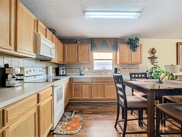 kitchen featuring a textured ceiling, tasteful backsplash, sink, white appliances, and dark hardwood / wood-style flooring