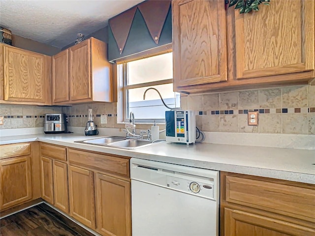 kitchen featuring dishwasher, a textured ceiling, tasteful backsplash, sink, and dark hardwood / wood-style flooring