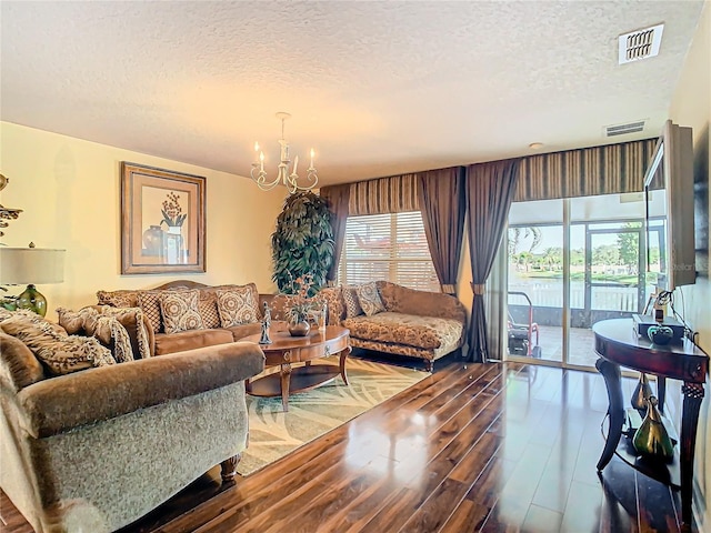 living room with a textured ceiling, a chandelier, and hardwood / wood-style floors