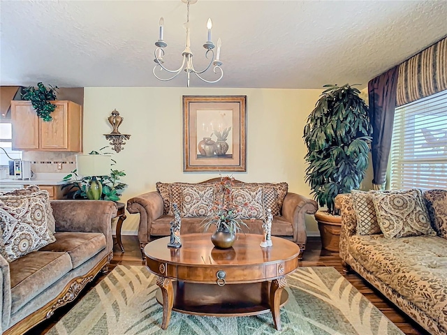 living room with hardwood / wood-style flooring, a chandelier, and a textured ceiling