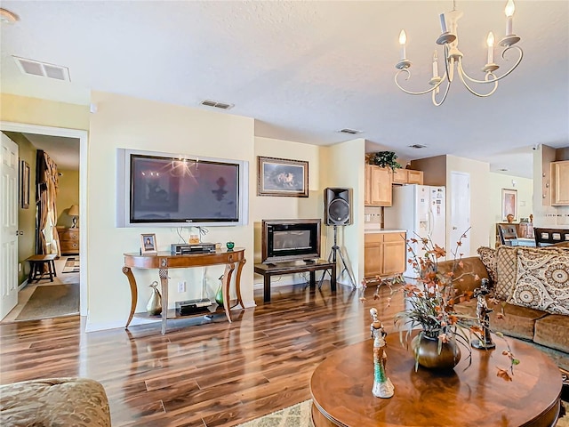 living room featuring a notable chandelier and dark wood-type flooring