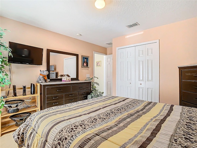 bedroom with a textured ceiling and a closet