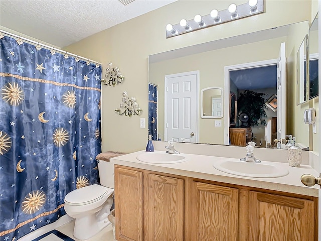 bathroom with tile patterned flooring, a textured ceiling, walk in shower, vanity, and toilet