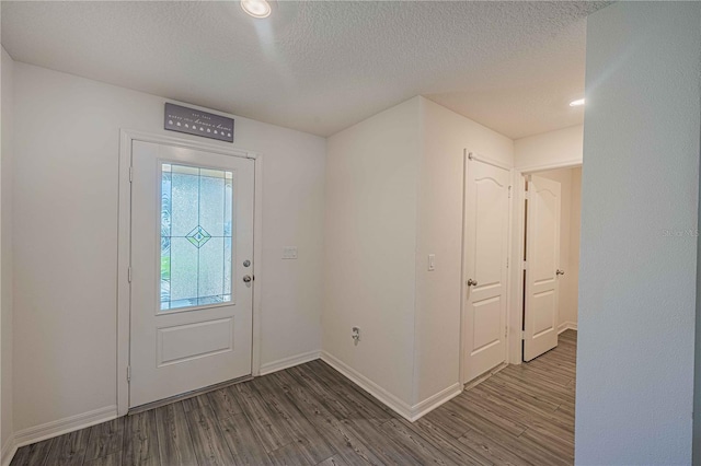 entryway with a textured ceiling and dark hardwood / wood-style flooring