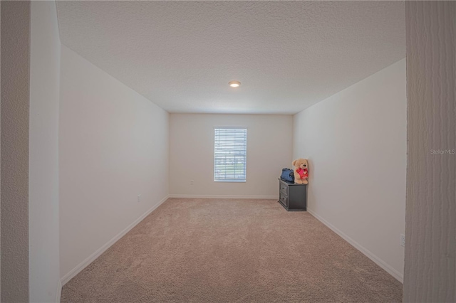 carpeted empty room featuring a textured ceiling