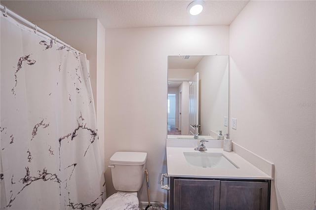 bathroom with a shower with shower curtain, a textured ceiling, vanity, and toilet