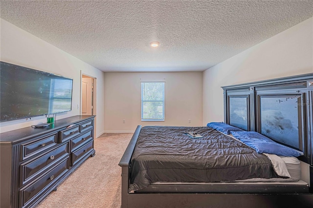 bedroom featuring light carpet and a textured ceiling