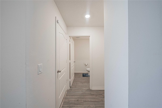 hallway featuring a textured ceiling and dark wood-type flooring