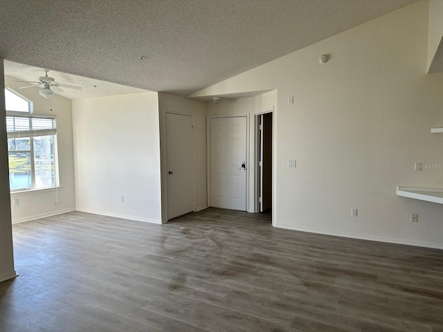 spare room with ceiling fan, dark hardwood / wood-style floors, lofted ceiling, and a textured ceiling