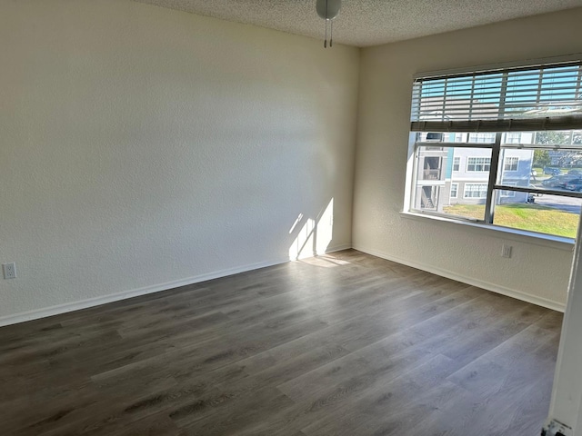 unfurnished room with a textured ceiling, ceiling fan, and dark hardwood / wood-style floors