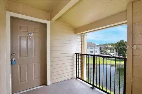 entrance to property with a water view and a balcony