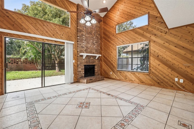 unfurnished living room featuring high vaulted ceiling, wood walls, and light tile patterned floors