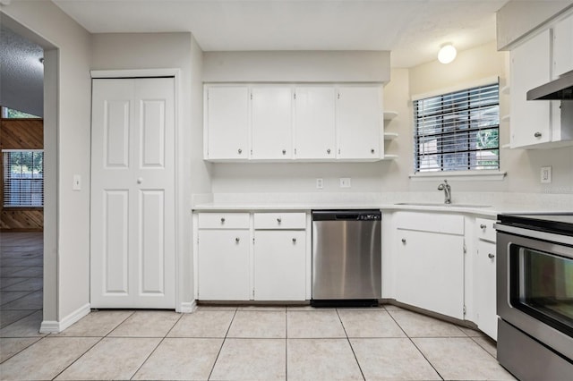 kitchen with light tile patterned flooring, stainless steel appliances, sink, and white cabinetry