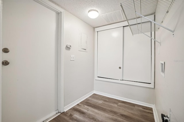 laundry room with a textured ceiling and wood-type flooring