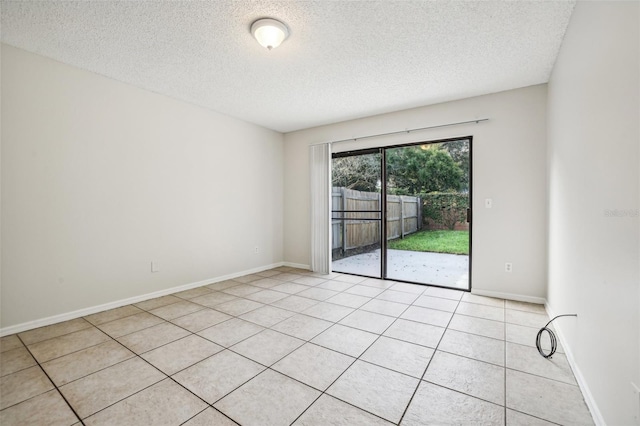 empty room featuring a textured ceiling and light tile patterned floors