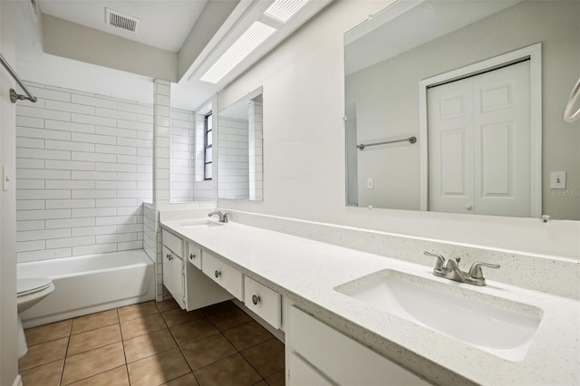 full bathroom featuring tile patterned floors, tiled shower / bath combo, vanity, and toilet