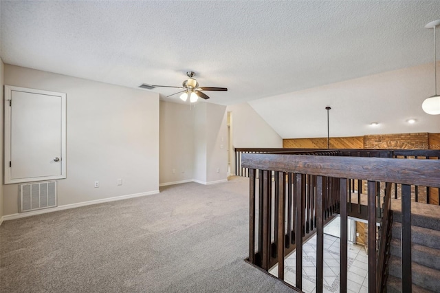 interior space with carpet floors, a textured ceiling, and vaulted ceiling