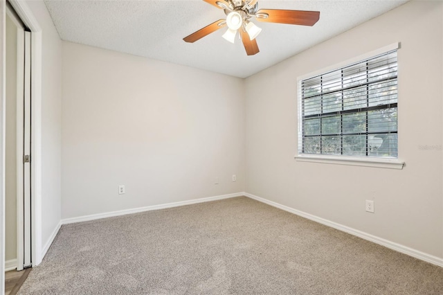 carpeted spare room with ceiling fan and a textured ceiling