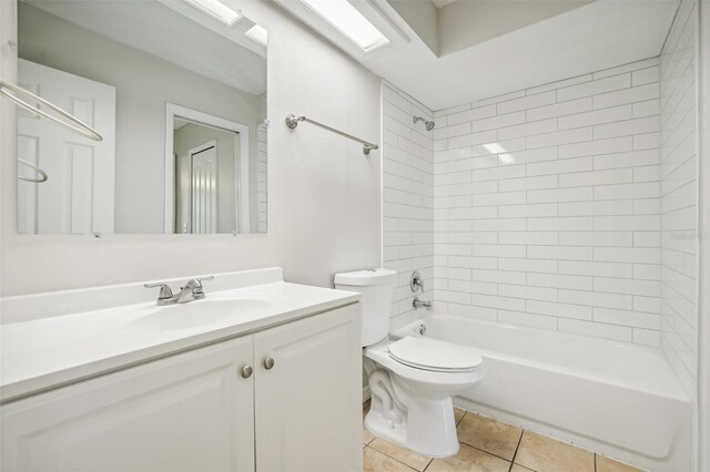 full bathroom with vanity, tiled shower / bath combo, toilet, and tile patterned flooring