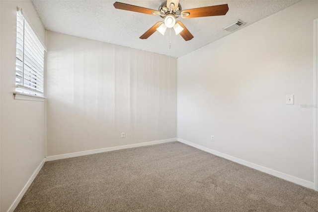 empty room featuring a textured ceiling, carpet floors, and ceiling fan