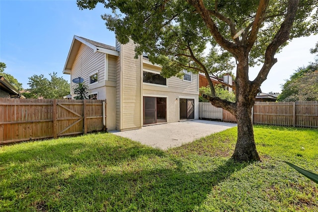 rear view of house featuring a patio and a yard