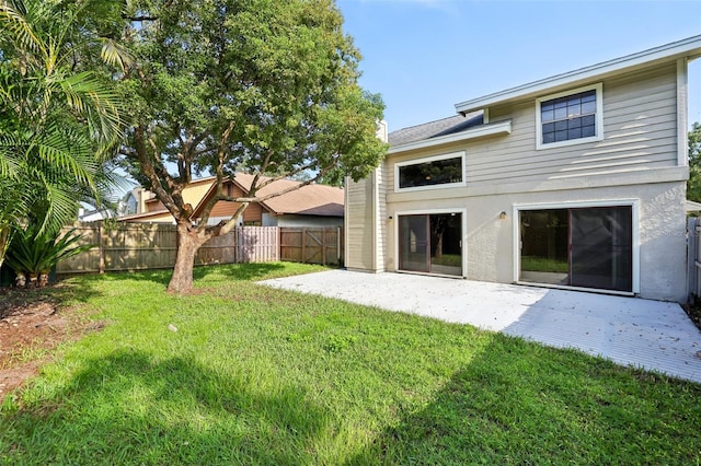 back of property featuring a patio and a yard