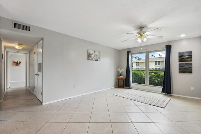 tiled spare room featuring ceiling fan