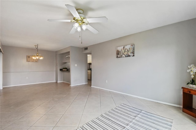 empty room featuring ceiling fan with notable chandelier and light tile patterned floors