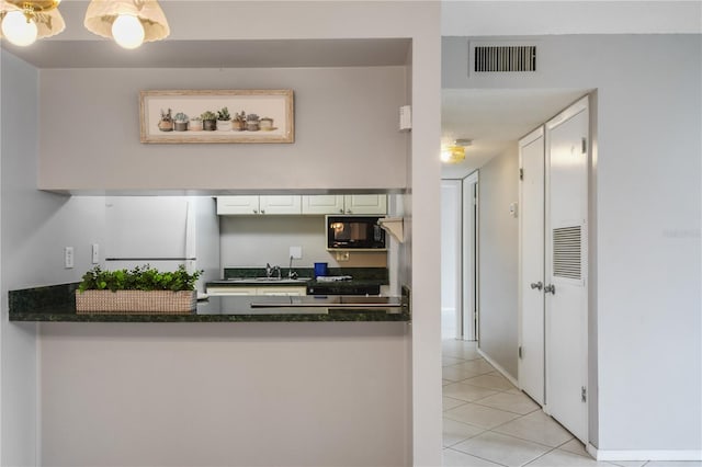 kitchen featuring white cabinets, light tile patterned flooring, and sink